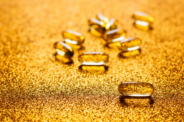 close up view of jelly capsules on shiny golden background - Photo, Image