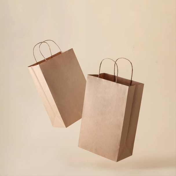Two paper bags in a container levitation on a clean beige background for shopping in a store and selling food products or marketing as well as for delivery. - Fotografie, Obrázek