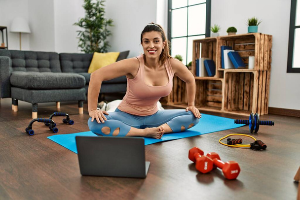 Young woman smiling confident having online stretching class at home - Zdjęcie, obraz