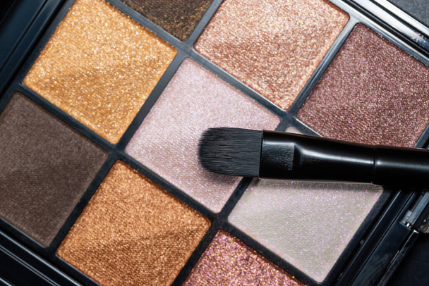 Close up photo of colourful eyeshadow palette with soft brush. - Photo, image