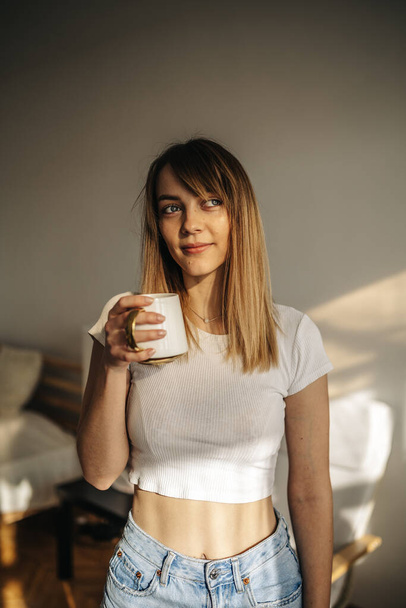 bella giovane donna con una tazza di caffè al mattino - Foto, immagini