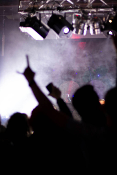 mãos levantadas de pessoas loucas em um concerto de rock, frente e fundo traseiro é borrado com efeito bokeh - Foto, Imagem