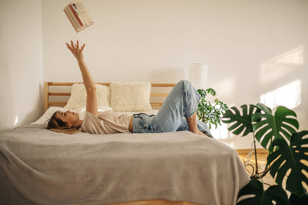 fiatal nő olvasás könyvet kanapén otthon - Fotó, kép