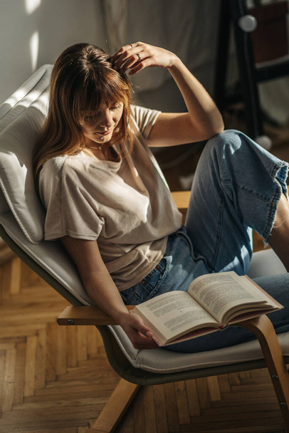 schöne junge Frau liest Buch im Zimmer - Foto, Bild