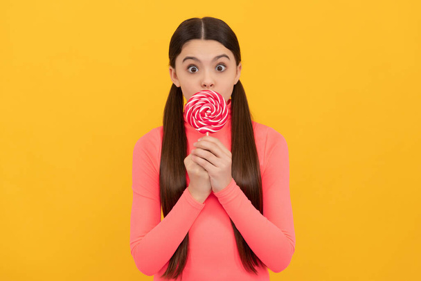 oh my god. teen dental care. sweet tooth. yummy. surprised girl hold lollipop. lollipop child. - Foto, imagen