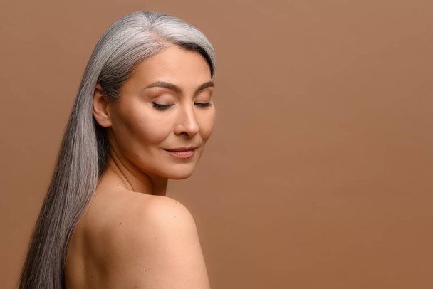 Headshot of attractive middle-aged Asian woman with naked shoulders and long silver hair - Φωτογραφία, εικόνα