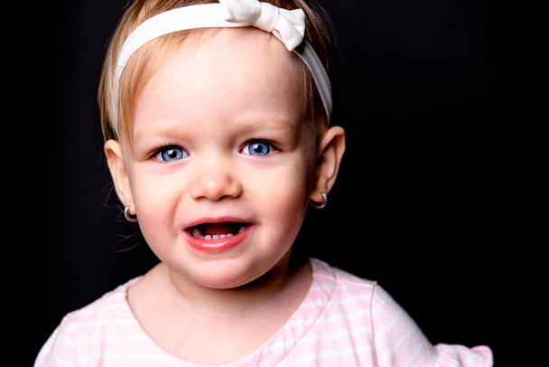 A cute little girl two years old over dark background - Foto, Imagen