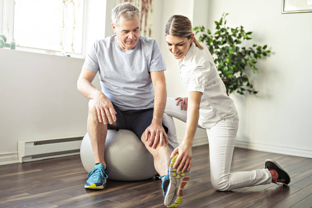 A Modern rehabilitation physiotherapy worker with senior client - Fotografie, Obrázek