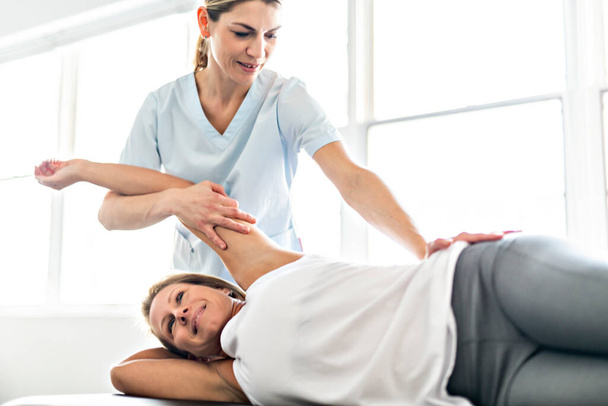 A Modern rehabilitation physiotherapy worker with woman client - Foto, Imagen