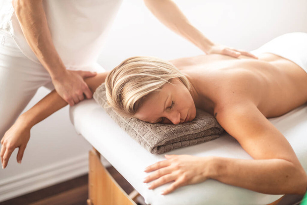 A Woman enjoying spa treatment at salon with masseur worker - Φωτογραφία, εικόνα
