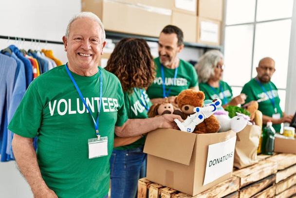 Gruppo di volontari di mezza età sorridenti felici che lavorano al centro di beneficenza. - Foto, immagini