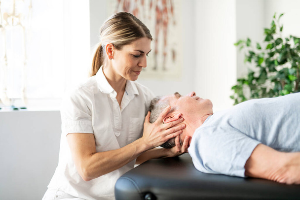 A Modern rehabilitation physiotherapy worker with senior client - Foto, Imagem
