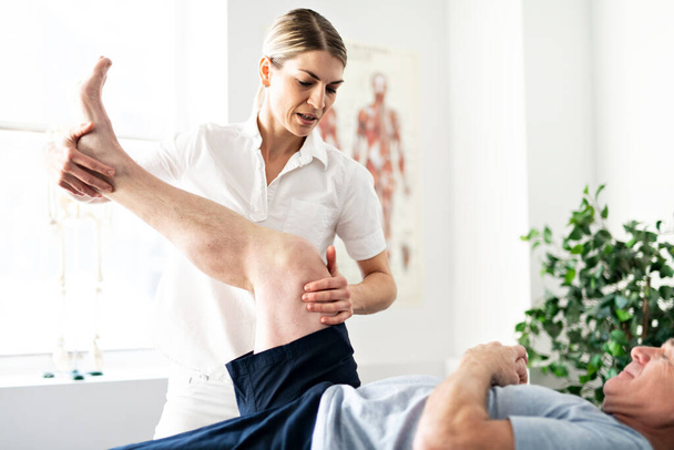 A Modern rehabilitation physiotherapy worker with senior client - Foto, Imagem