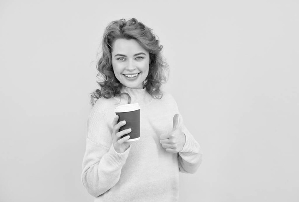 счастливая рыжая женщина выпить вынос кофе из чашки на желтом фоне, скопировать пространство, идеальный кофе - Фото, изображение
