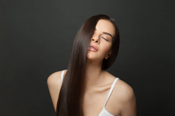 Gyönyörű barna nő egészséges hosszú haj fekete háttér - Fotó, kép