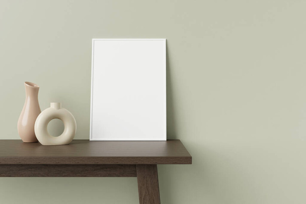 Minimalistische und saubere vertikale weiße Poster- oder Fotorahmen-Attrappe auf dem Holztisch, der mit dekorativer Vase an der Zimmerwand lehnt. 3D-Rendering. - Foto, Bild