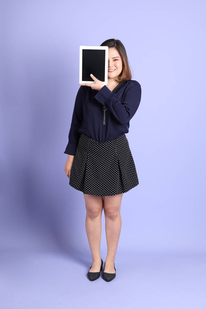 The chubby Asian woman standing on the purple background with the casual clothes. - Φωτογραφία, εικόνα