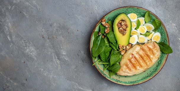 Low carb high fat breakfast. Ketogenic diet. avocado, grilled chicken fillet, quail egg, spinach, walnut, Long banner format. top view. - Photo, Image