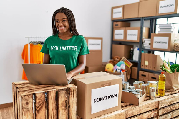 Mladá africká americká žena v dobrovolnické uniformě pracující v charitativním centru - Fotografie, Obrázek