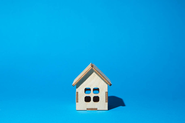 Dřevěný dům na modrém pozadí. Koncept nákupu a prodeje nemovitostí. Realitní služby - Fotografie, Obrázek