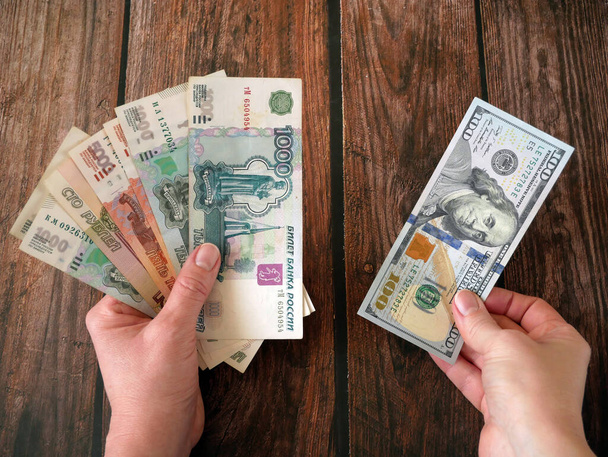 Papierbanknoten Russischer Rubel gegen hundert amerikanische Dollar. Das Gesicht des russischen Geldes ist Rubel. Nahaufnahme des russischen Rubels. Das Konzept des Inflationsgeldes in Russland, Nahaufnahme - Foto, Bild