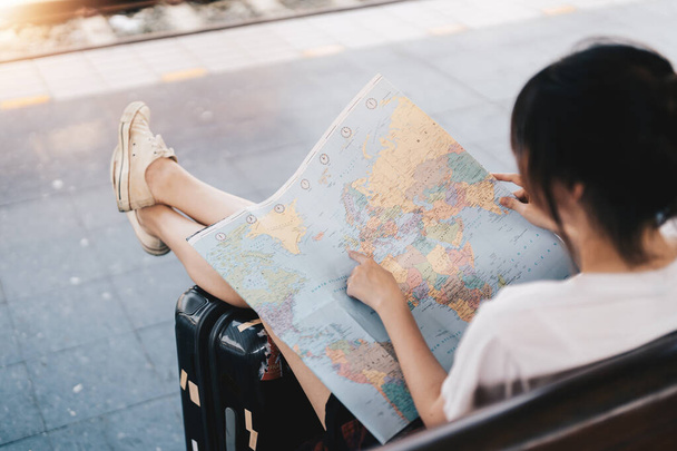 Tylna strona podróżnika dziewczyna szuka właściwego kierunku na mapie, podróżując pociągiem wzdłuż Azji, wolności i aktywnego stylu życia koncepcja - Zdjęcie, obraz