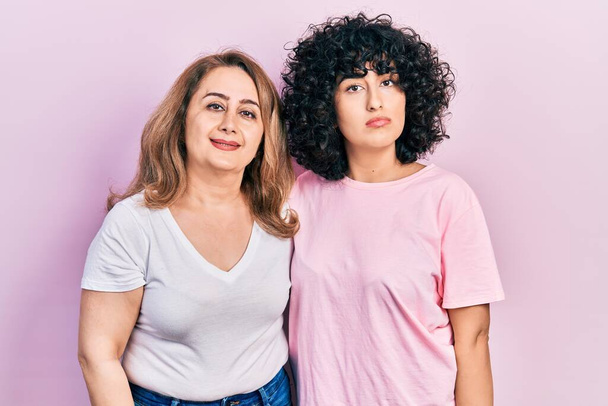 Middle east mother and daughter wearing casual clothes relaxed with serious expression on face. simple and natural looking at the camera.  - Fotó, kép