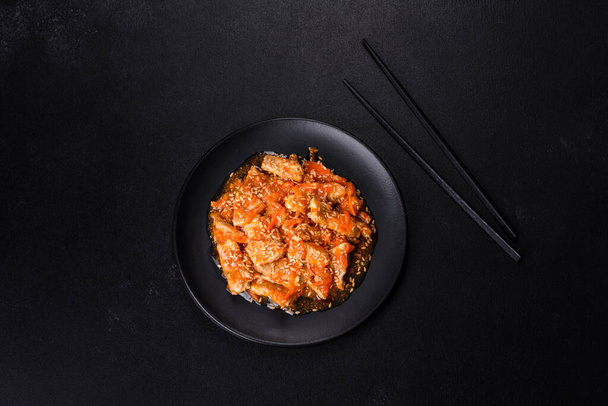 Teriyaki-Huhn mit Soße, Sesam, Kräutern und Gewürzen auf dunklem Betongrund. Asiatische Küche - Foto, Bild