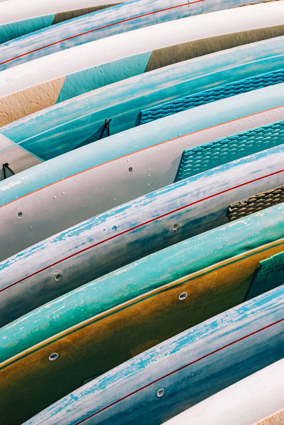 Close-up of colorful paddle boards for rent. Leisure water activities - Фото, изображение