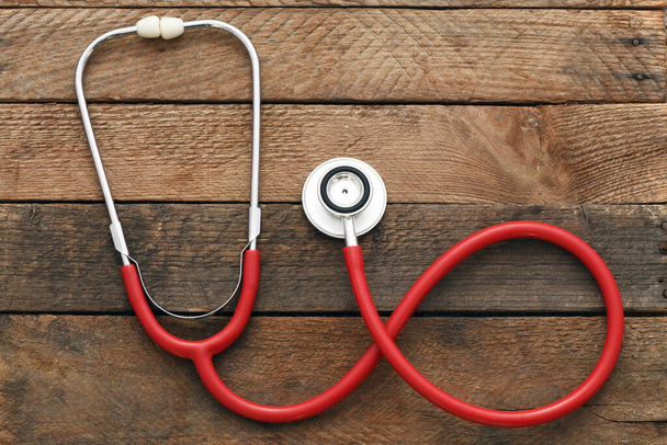 Стетоскоп на деревянном фоне. Здоровье сердца, концепция медицинского страхования, Всемирный день сердца, Всемирный день здоровья, Всемирный день гипертонии - Фото, изображение