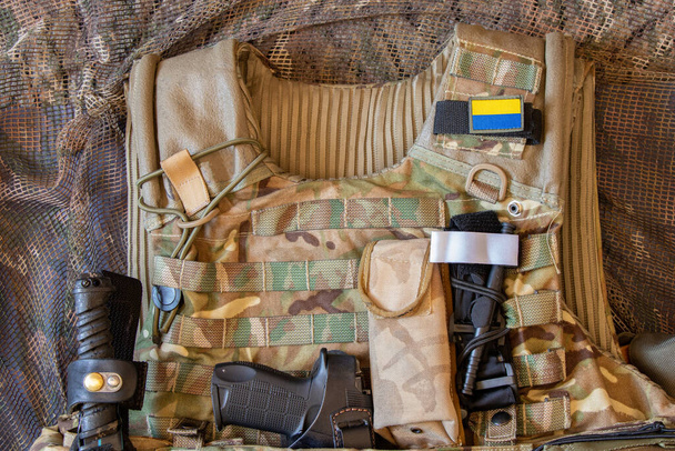 Military reinforced bulletproof vest and pistol, weapon, uniform of a Ukrainian soldier in the war, army of Ukraine 2022 - Фото, изображение