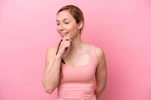 Young caucasian woman isolated on pink background looking to the side and smiling - Fotografie, Obrázek