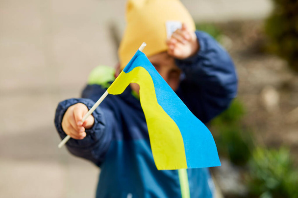Le petit garçon patriotique tient le drapeau ukrainien. Restez avec l'Ukraine. Soutenez l'Ukraine. Arrêtez le concept d'agression russe. Arrêtez la guerre en Ukraine. Priez pour l'Ukraine - Photo, image