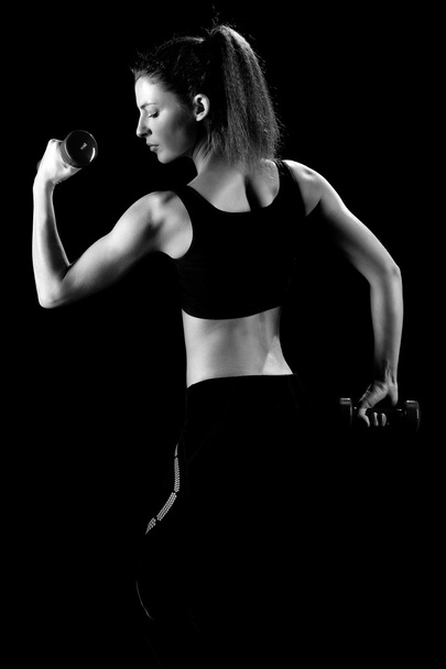 beautiful sporty muscular woman working out with dumbbells  - Foto, Imagen