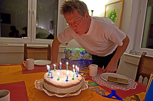 Mann pustet Geburtstagstorte aus - Foto, Bild