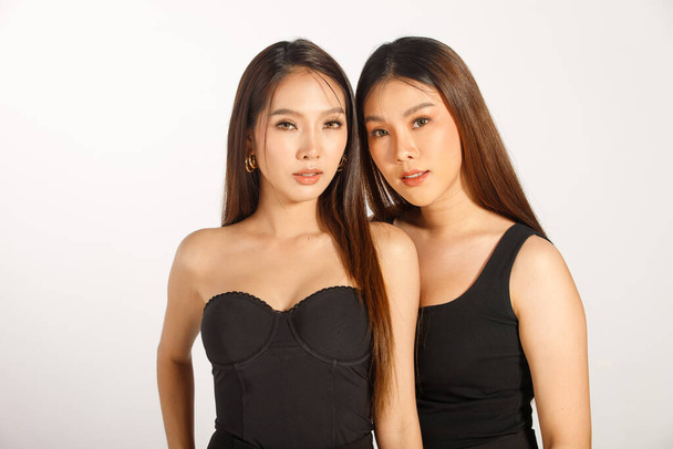Two Best Friends Half Body Portrait of 20s Asian beautiful Women black long straight hair wear black dress. Females express feeling smile happy and hug close together over white Background isolated - Fotó, kép