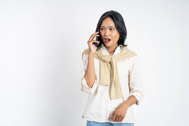 shocked asian woman making a call using a cell phone - Fotó, kép