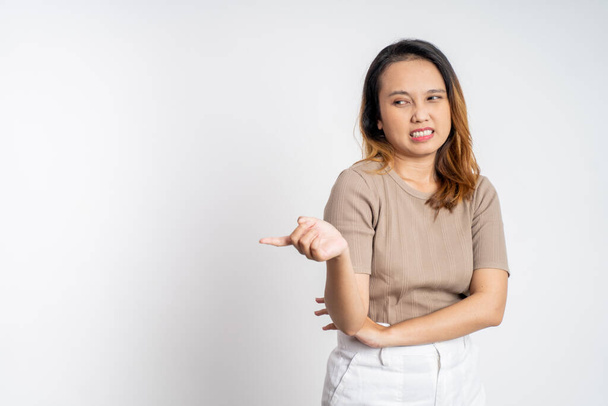 cynical asian woman expression while standing over isolated background - Foto, afbeelding