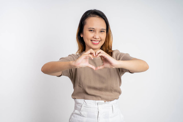 woman smiling in heart shape with fingers on isolated - Фото, изображение
