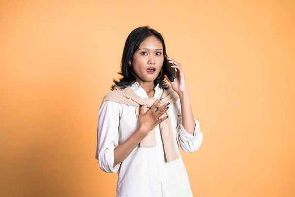 shocked asian woman making a call using a cell phone - Foto, immagini