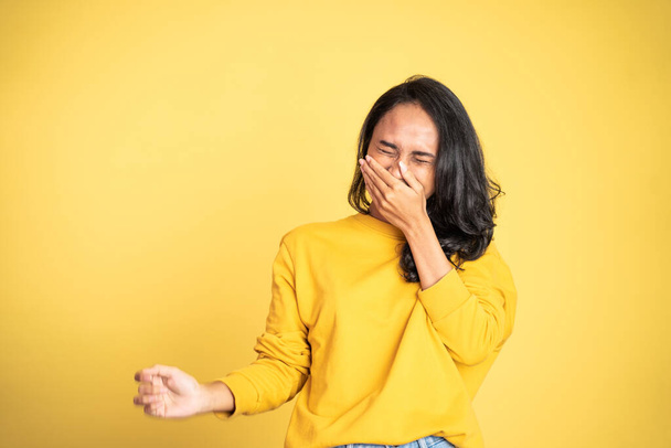 woman laughing hard cover her mouth over yellow background - Fotografie, Obrázek