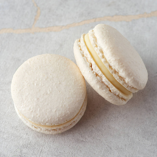 Sweet vanilla macarons on a stone background. Traditional French dessert - Fotó, kép