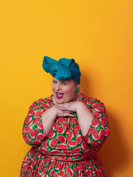 Funny plus size sexy model woman with trendy makeup, fashionable overweight blonde in colorful dress posing at the yellow background in studio. - Fotoğraf, Görsel
