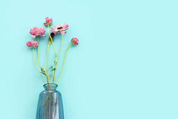 Top view image of pink flowers composition over blue background - Foto, Bild