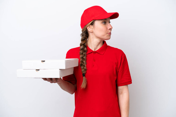 pizza dodávka žena s pracovní uniformou vyzvednutí pizza boxy izolované na bílém pozadí při pohledu na stranu - Fotografie, Obrázek
