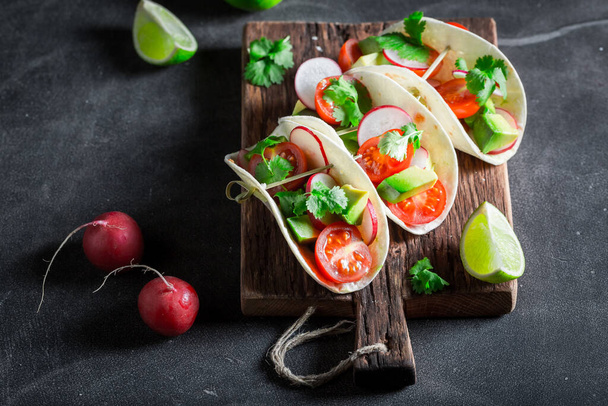 Delicious and homemade tacos with fresh vegetables and herbs. Tacos with vegetables as a Mexican snack. - Zdjęcie, obraz