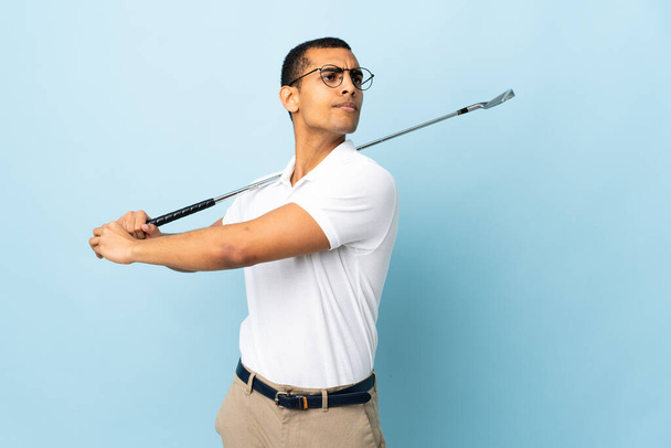 African American man over isolated blue background playing golf - Photo, Image