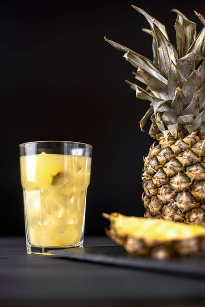 Fermented pineapple lemonade on a black background - Foto, imagen