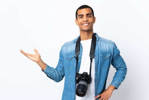 Jovem fotógrafo afro-americano homem sobre fundo branco isolado segurando copyspace imaginário na palma da mão
 - Foto, Imagem