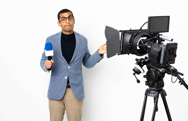 Reportér Afroameričan drží mikrofon a hlásí zprávy o izolovaném bílém pozadí s pochybnostmi při zvedání rukou - Fotografie, Obrázek